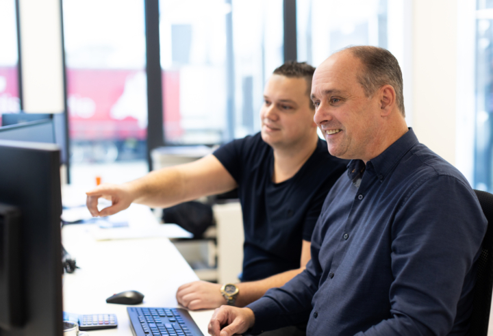 Two BF Global employees discussing at a computer screen