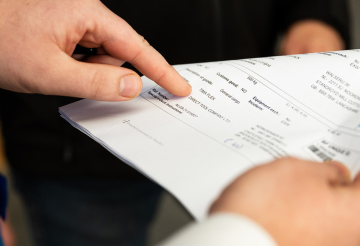 Hands signing a logistics document or bill of lading